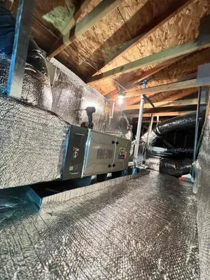 Interior view of an attic featuring a modern HVAC system installation with insulated ducts and a furnace, showcasing the work of AIS Heating & Air Conditioning in Livermore.
