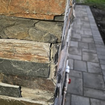 Close-up view of a neatly stacked stone wall leading to a paved path, showcasing ARP Hardscape's craftsmanship in San Leandro.