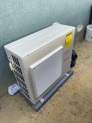 "Exterior air conditioning unit near a wall, representing environmental control and comfort, associated with A-1 Performance Auto Repair in Sunnyvale."