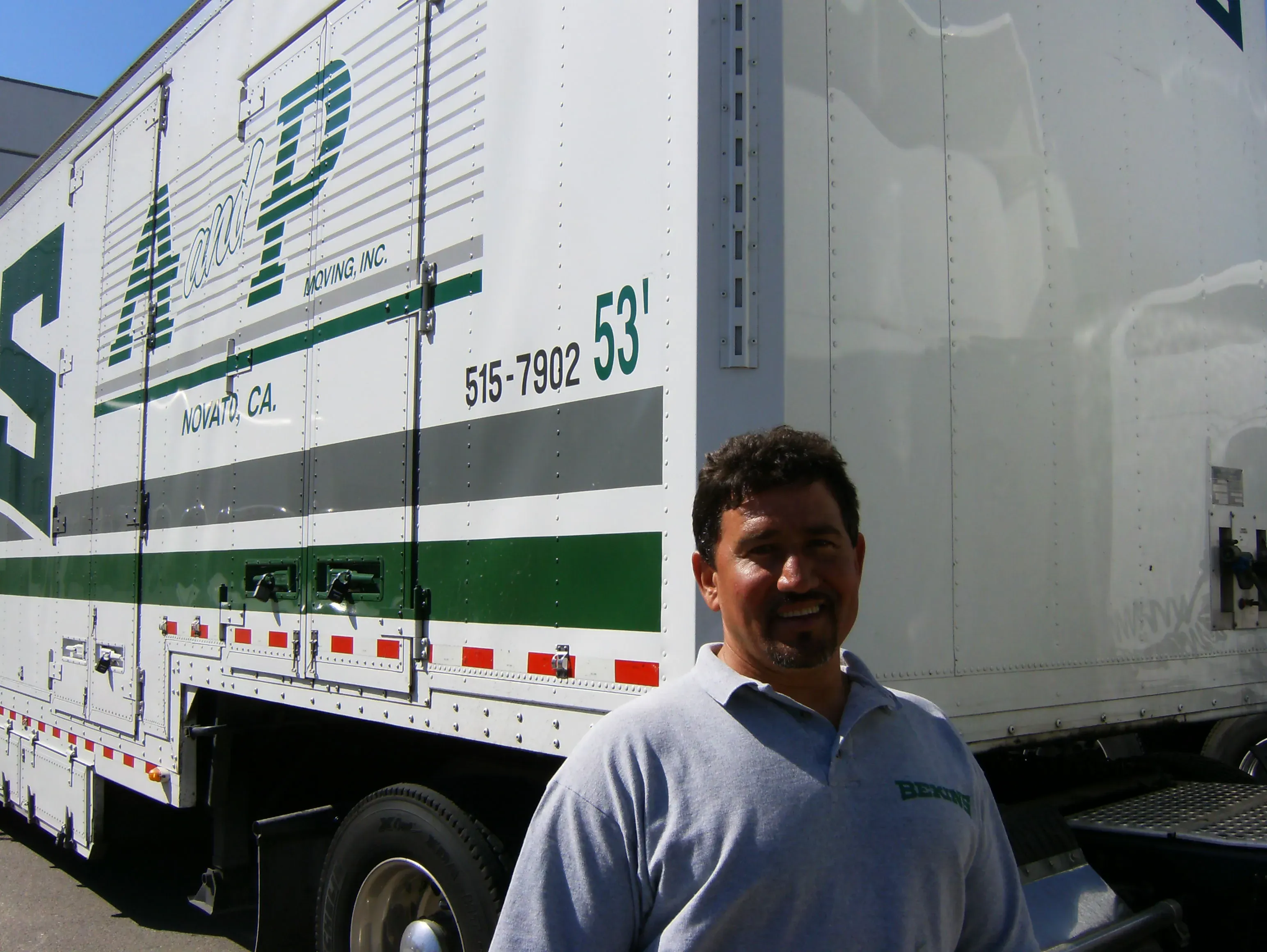 Man standing in front of an A and P Moving, Inc. truck in Novato, dressed in a gray shirt.