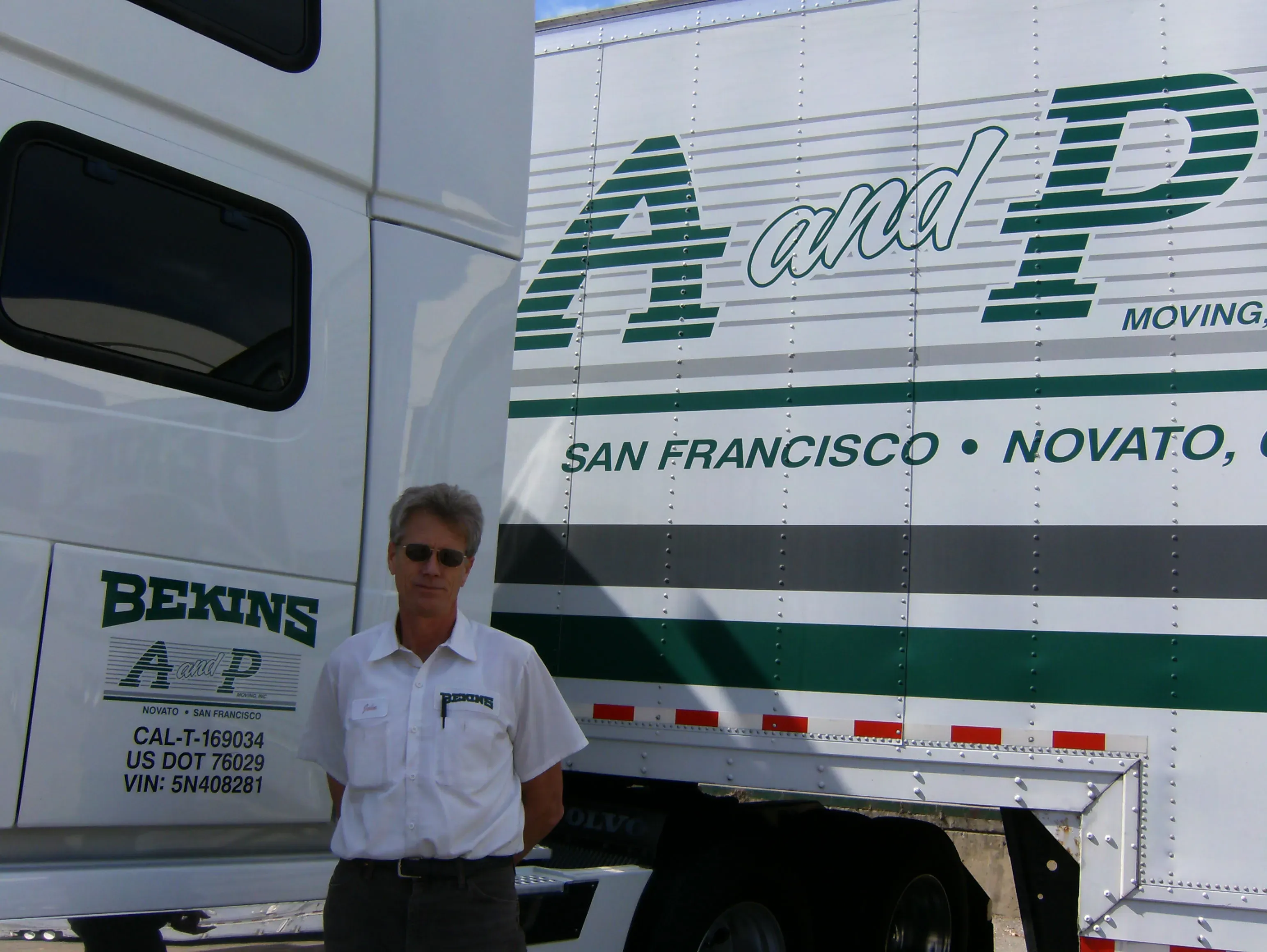 A person stands in front of a large moving truck with A and P Moving, Inc. logo and "San Francisco, Novato, CA" written on the side.