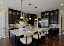 A modern kitchen with dark cabinets, marble countertops, stainless steel appliances, and pendant lighting, designed by Abrew Repair and Construction in Pleasanton.