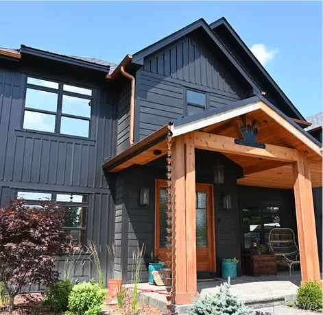 A modern house exterior with dark siding and a wooden entryway, showcasing Abrew Repair and Construction's work in Pleasanton.