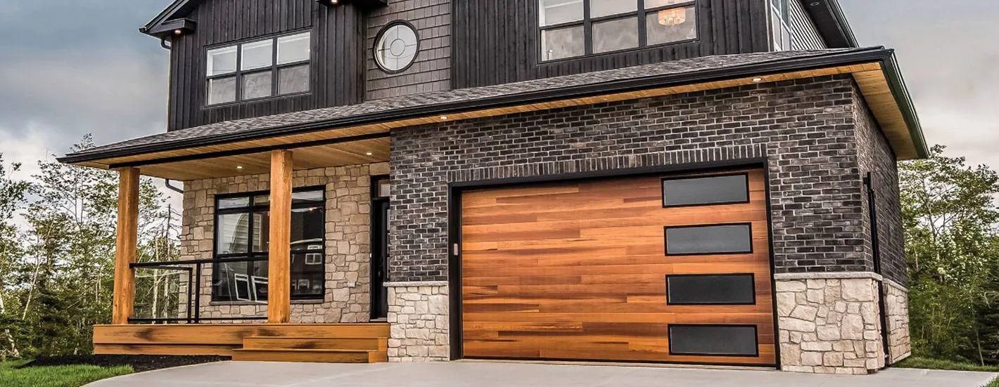"Modern house with a wooden garage door, featuring brick and stone facade, showcasing Ace's Garage Door Repair & Installation in Hayward."