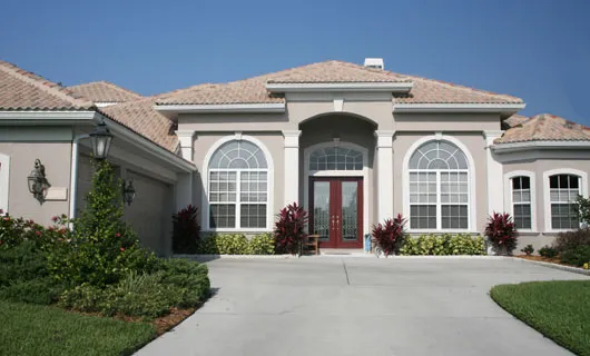 Front view of a modern, elegant house with a symmetrical design, featuring large arched windows and a neatly landscaped driveway in Concord, showcasing AcuStruct Inc.'s workmanship.