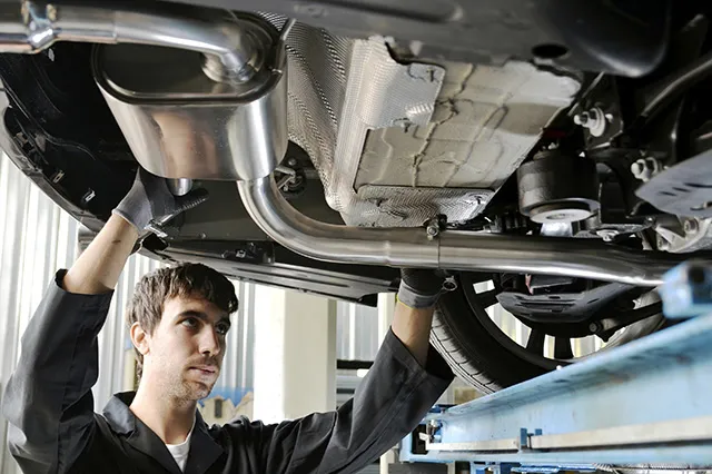 Mechanic inspecting the undercarriage of a car on a lift at Acur-It Auto Repair in Rohnert Park.