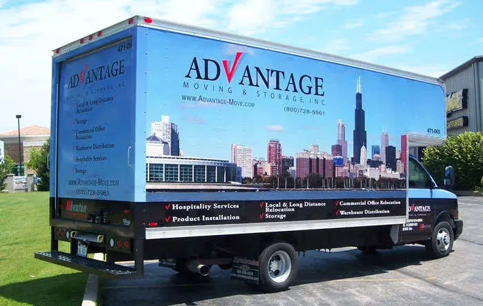 A moving truck from Advantage Moving & Storage, featuring a city skyline graphic, parked outdoors in Milpitas.