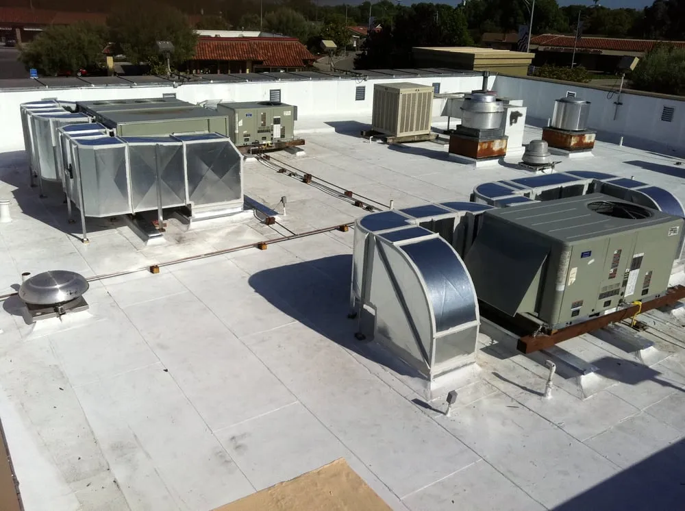 Rooftop HVAC units with ductwork and ventilation systems on a flat roof, installed by Air Quality Heating & Air Conditioning in San Jose.