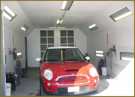 A red car in a clean, well-lit auto service bay at Alameda Auto Care Center in Alameda.