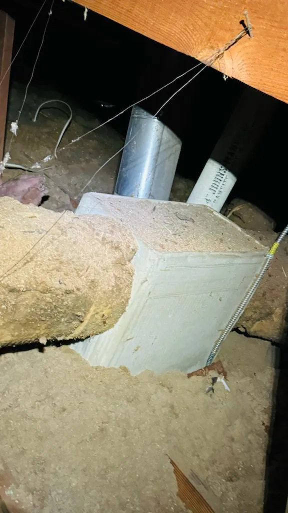A close-up view of attic ductwork insulation showcasing dust and debris in a San Jose home by AllBayInsulation&HVAC.