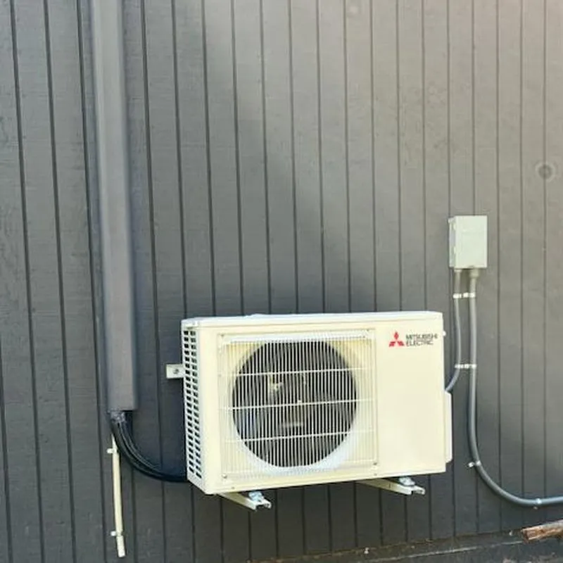 A Mitsubishi Electric air conditioning unit installed on an exterior wall, showcasing the installation by AllBayInsulation&HVAC in San Jose.