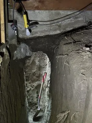 An excavation site showing a partially exposed concrete section with construction tools, exemplifying All Seasons Construction's work in Oakland.