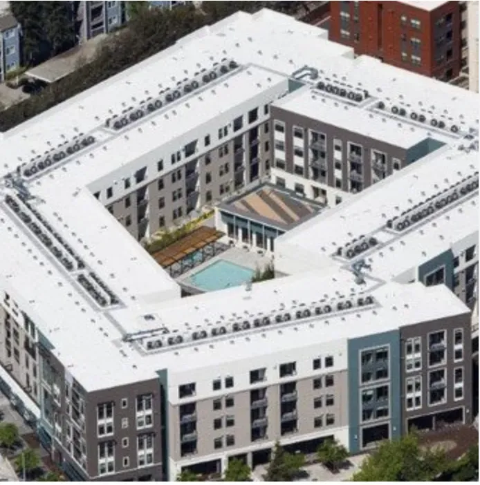 Aerial view of a large, modern residential complex with a white roof and central courtyard in San Jose, featuring work by All Seasons Roofing & Waterproofing, Inc.