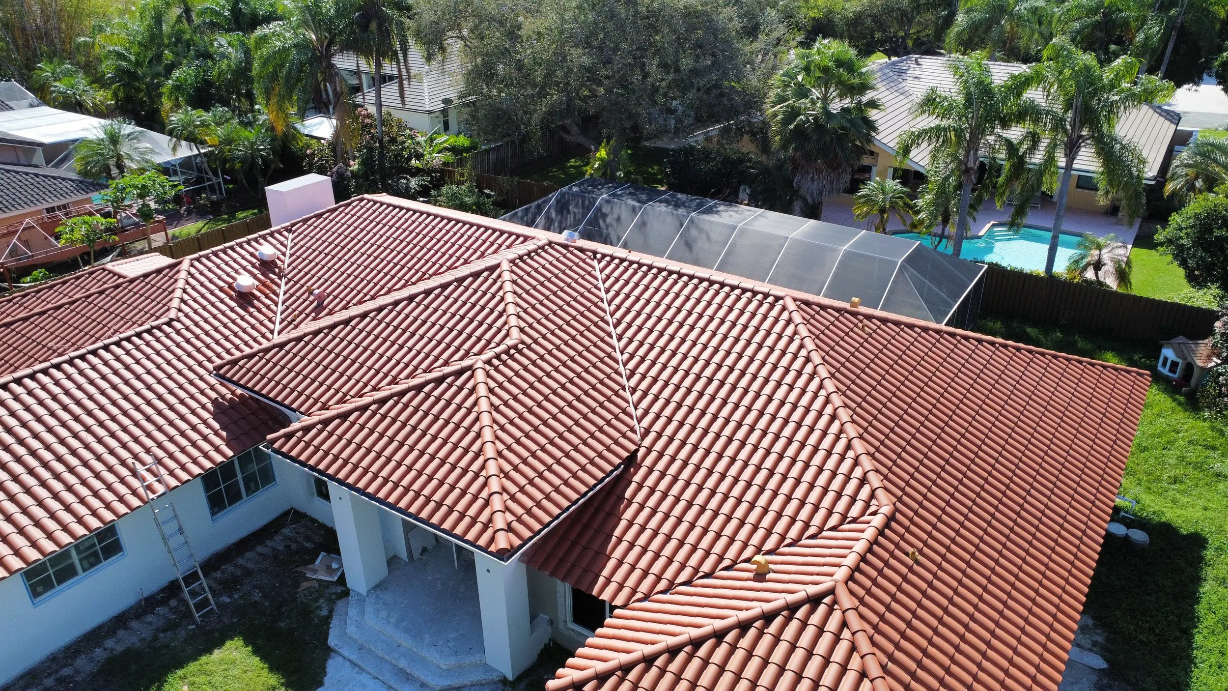"Aerial view of a red tile roof installed by Alonso Roofing in a Hialeah neighborhood, showcasing meticulous craftsmanship and design."