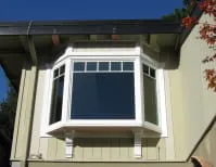 A photo of a bay window with white trim on a residential building, showcasing the work of American Home Renewal, Inc. in South San Francisco.