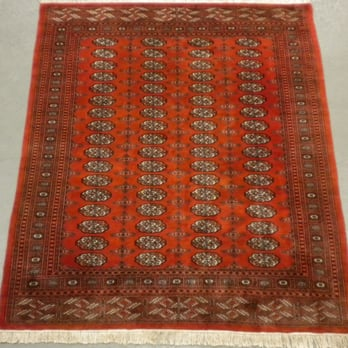 An intricately patterned red rug, showcasing detailed geometric designs, representing Artisan Rug Care's expertise in Santa Cruz.