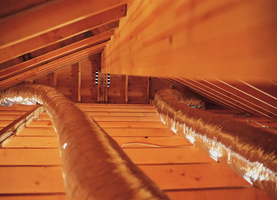Interior view of an attic with exposed wooden beams and installed ductwork, showcasing the craftsmanship of AtticBros in SanJose.