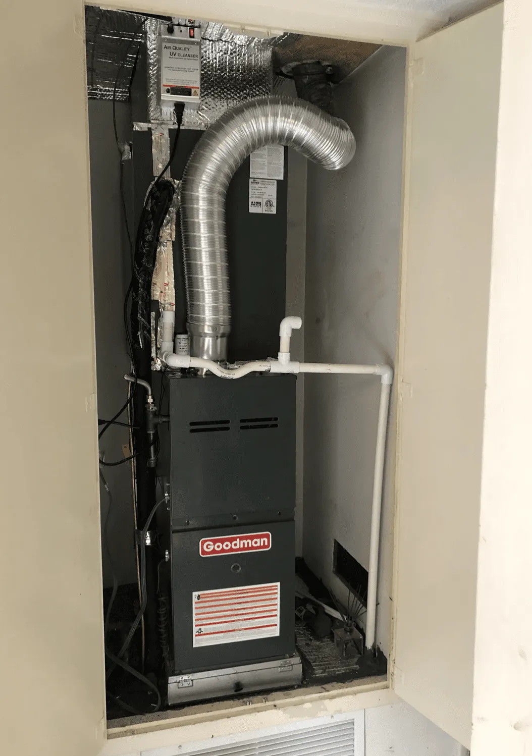 Image of a Goodman HVAC unit installed inside a compartment, featuring ductwork and ventilation in San Leandro by Atticare Construction.