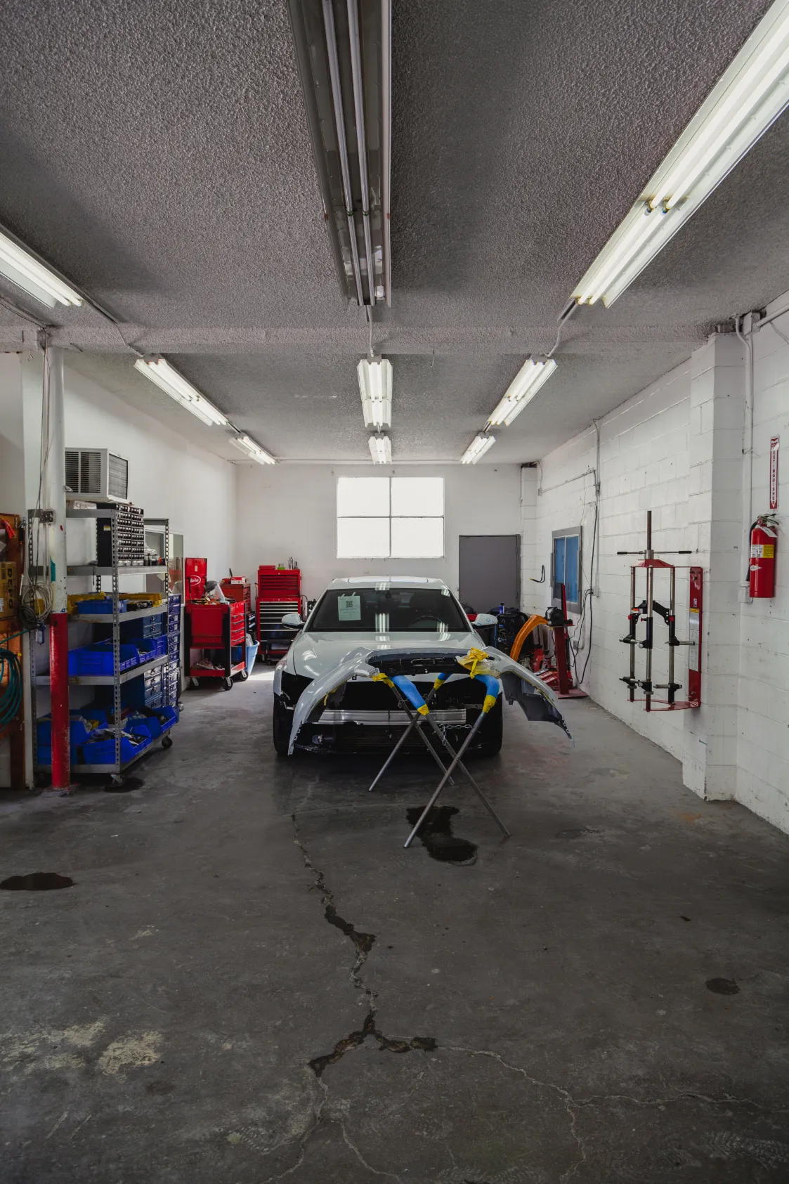 A car undergoing repair in a well-equipped auto body shop at AutoShield Collision in Santa Clara.