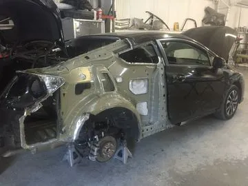 A car undergoing detailed repair work at AutoCollisionExperts in Sunnyvale, showcasing the restoration process with parts removed for precision.