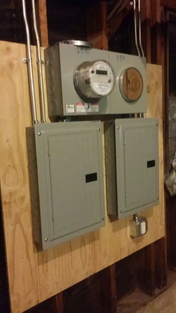 Electrical panels and a meter installed on a wooden board, showcasing the work by BV Electric Inc. in San Francisco.
