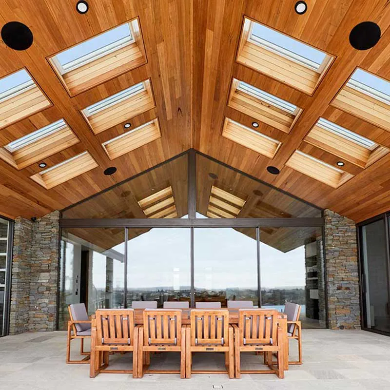 Modern patio with wooden seating and a ceiling with skylights, designed with glass walls by B & L Glass in Santa Rosa.