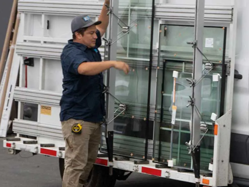 Worker from B & L Glass in Santa Rosa managing glass installation materials on a worksite.