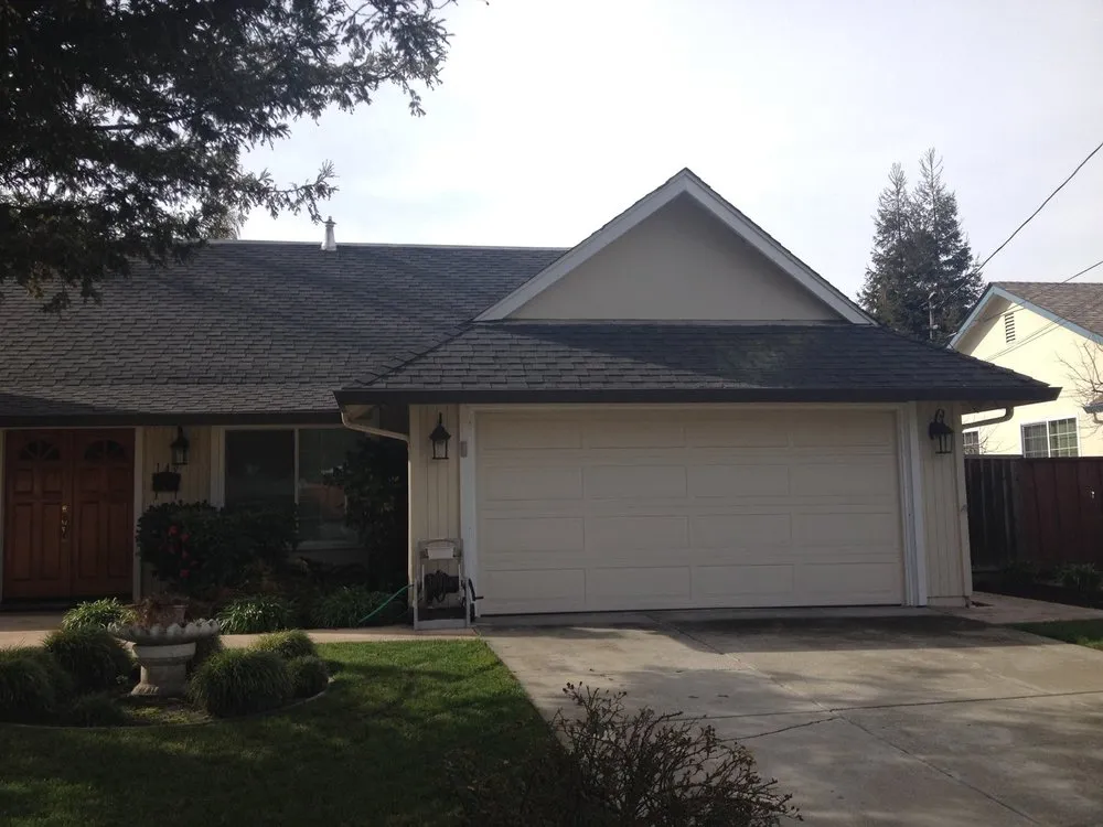 "A house with a new shingle roof, installed by Bay Valley Roofing, featuring a two-car garage in a residential neighborhood in Concord."