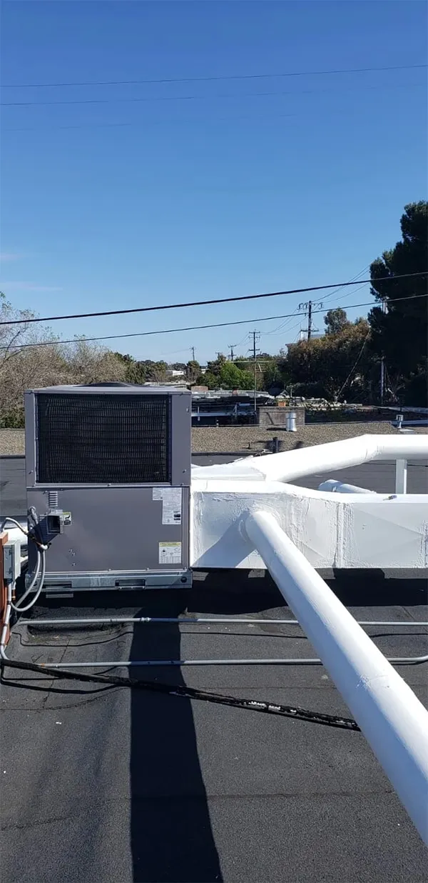 Rooftop HVAC unit installed by Bayhill Heat & Air, Inc. on a building in San Mateo, under a clear blue sky.