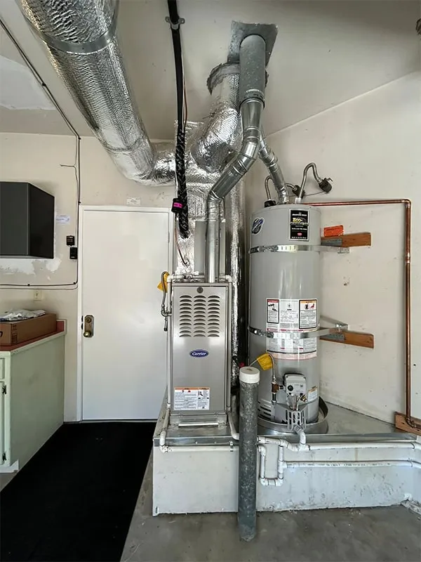 "HVAC system and water heater installation in a white room, showcasing ductwork and piping, representing Bayhill Heat & Air, Inc. in San Mateo."