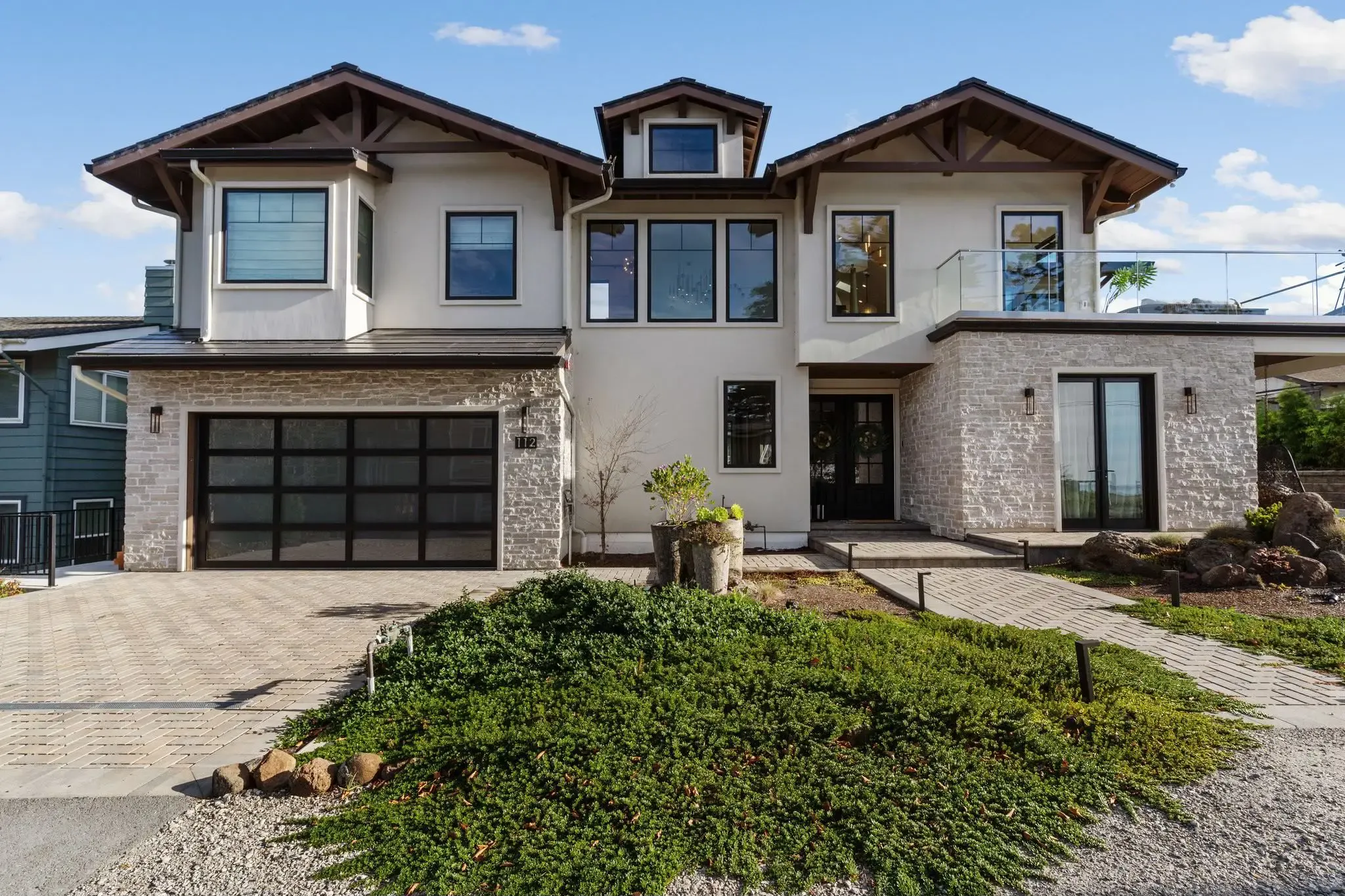 A modern two-story house with large windows and a stone facade, built by Best Construction in San Jose.