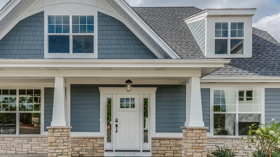 Image of a house exterior with blue siding, large windows, and a welcoming front entrance, showcasing the craftsmanship of Best Exteriors Construction, Inc. in Rocklin.