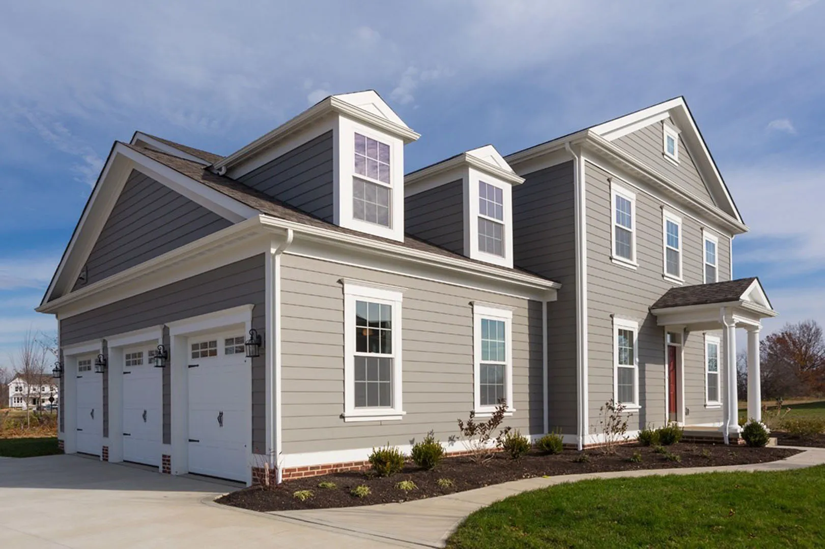 A beautifully constructed two-story gray house with white trim and a triple car garage, built by Best Exteriors Construction, Inc. in Rocklin.