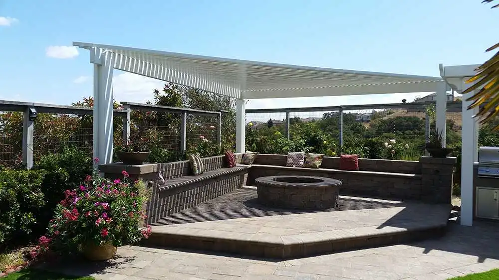 Image of an outdoor patio with a white pergola, seating area, and fire pit, designed by Black Diamond Paver Stones & Landscape, Inc. in San Jose.