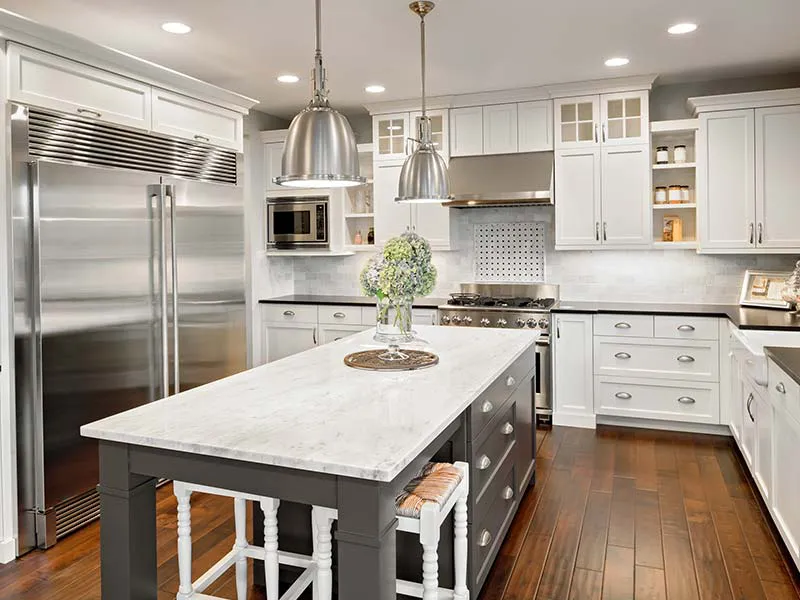 Modern kitchen interior designed by Cal Summit Builders in San Rafael, featuring a large marble island, pendant lighting, and stainless steel appliances.