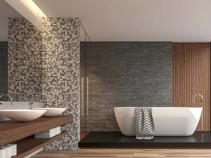 A modern bathroom designed by Cal Summit Builders in San Rafael featuring a freestanding bathtub, mosaic accent wall, dual sinks, and contemporary decor.