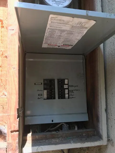 "Open electrical panel box mounted on a wall, showcasing circuit breakers with labels, part of California Power and Light's infrastructure in Morgan Hill."
