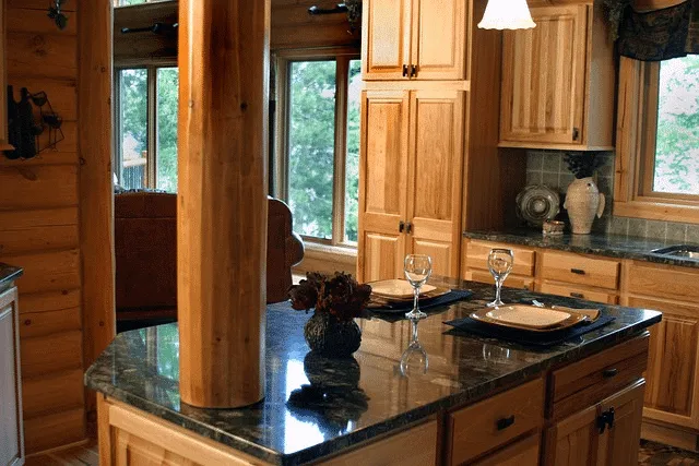 "A beautifully designed kitchen with wooden cabinets, granite countertops, and elegant table settings, highlighting the craftsmanship of Castles Home Service in Salinas."