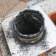 A chimney top covered in soot and ash, highlighting the need for cleaning by Chimney Clean Company in San Jose.
