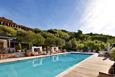 Scenic view of a luxurious outdoor pool surrounded by lush greenery and comfortable seating at Classic Pools in Concord.
