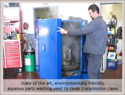 A technician at Collie Autoworks in San Rafael operates a blue aqueous parts washer, highlighting eco-friendly cleaning technology for automotive parts.