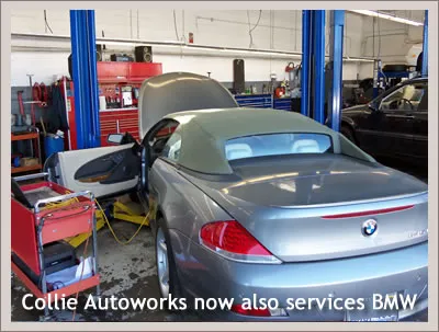 A BMW convertible inside a workshop with blue car lifts and red tool cabinets at Collie Autoworks in San Rafael.