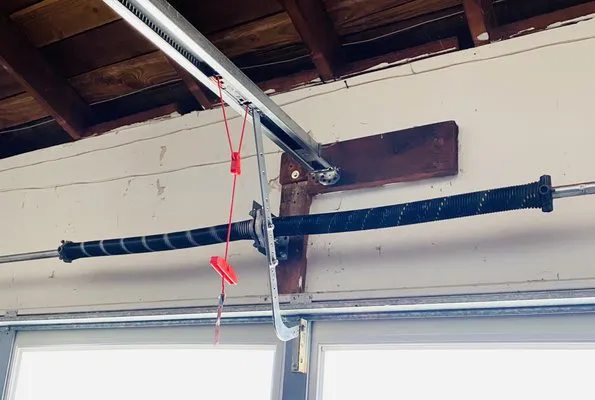 Close-up of a garage door spring and pulley system, showcasing precise engineering by Contra Costa Door in Concord.
