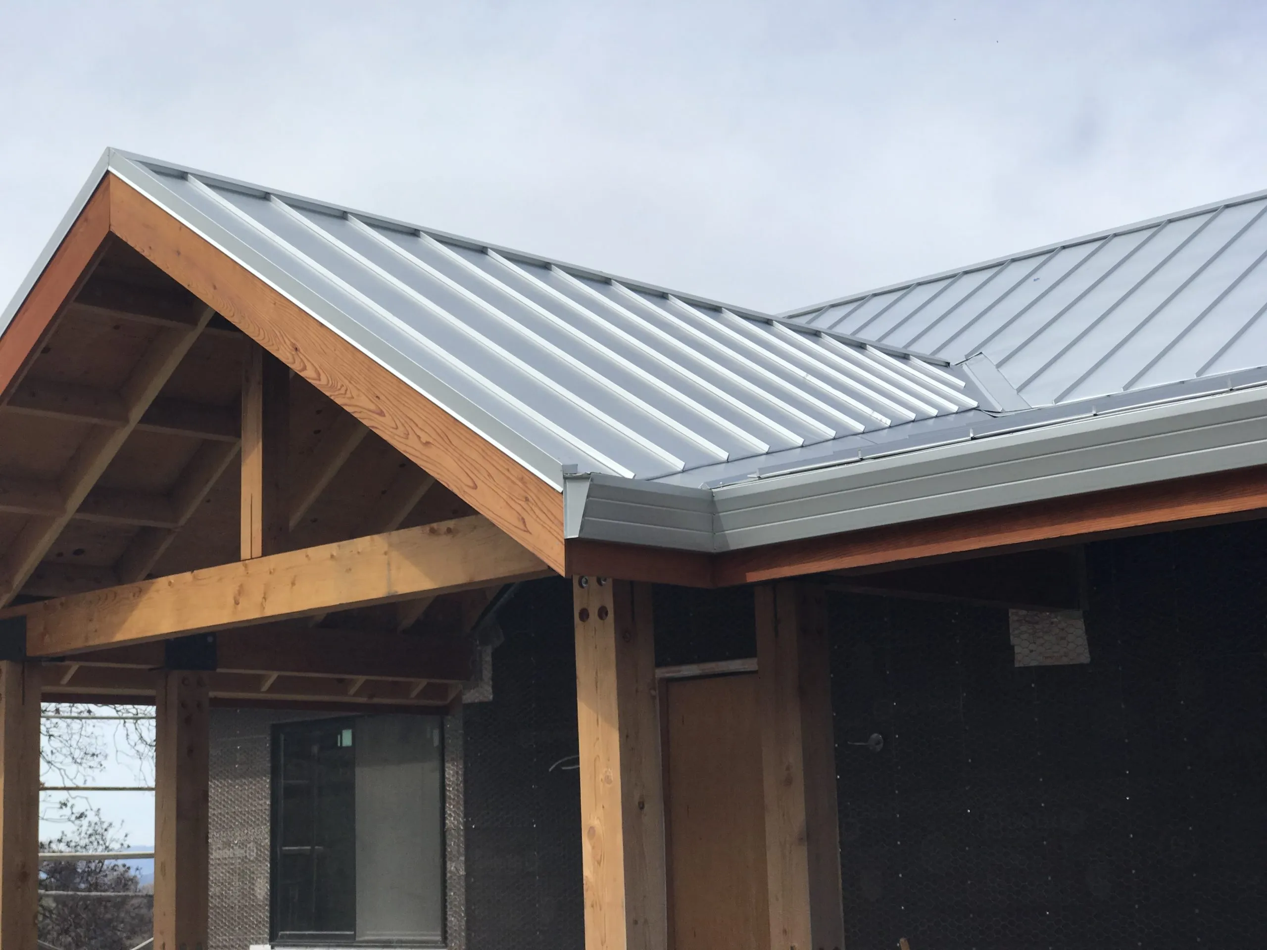 A newly installed metal roof with visible wooden beams, showcasing the craftsmanship of Crandall Roofing Inc. in Santa Rosa.