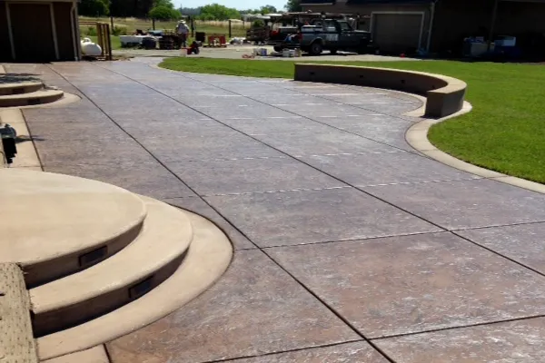 A landscaped driveway with decorative concrete and curved steps, designed by Creative Image Landscaping in Vacaville.
