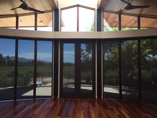 A modern room in Rohnert Park with floor-to-ceiling windows showcasing outdoor scenery, featuring installations by Creative Window Fashions.