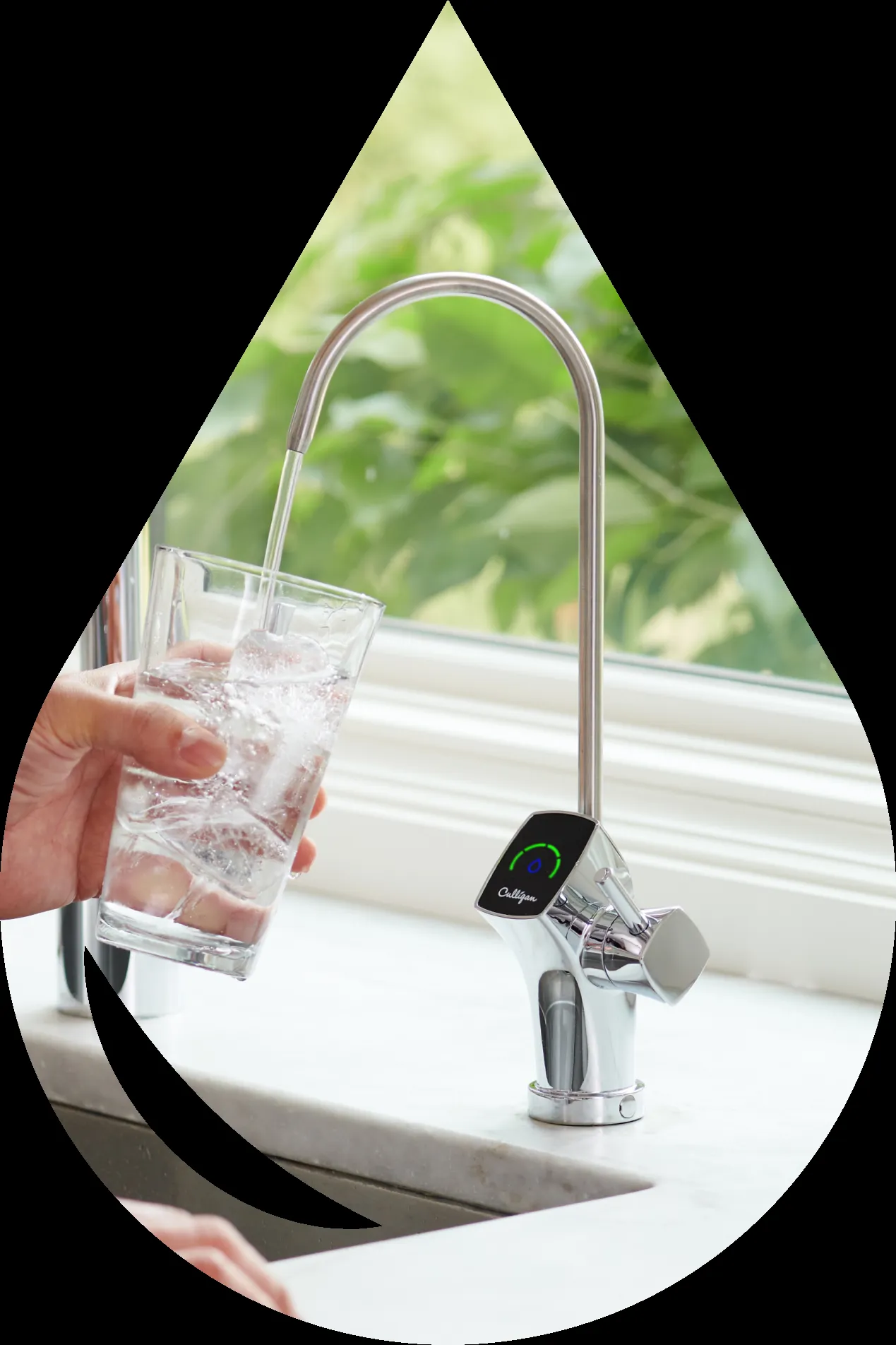 A hand filling a glass with water from a Culligan-branded faucet in a kitchen setting.