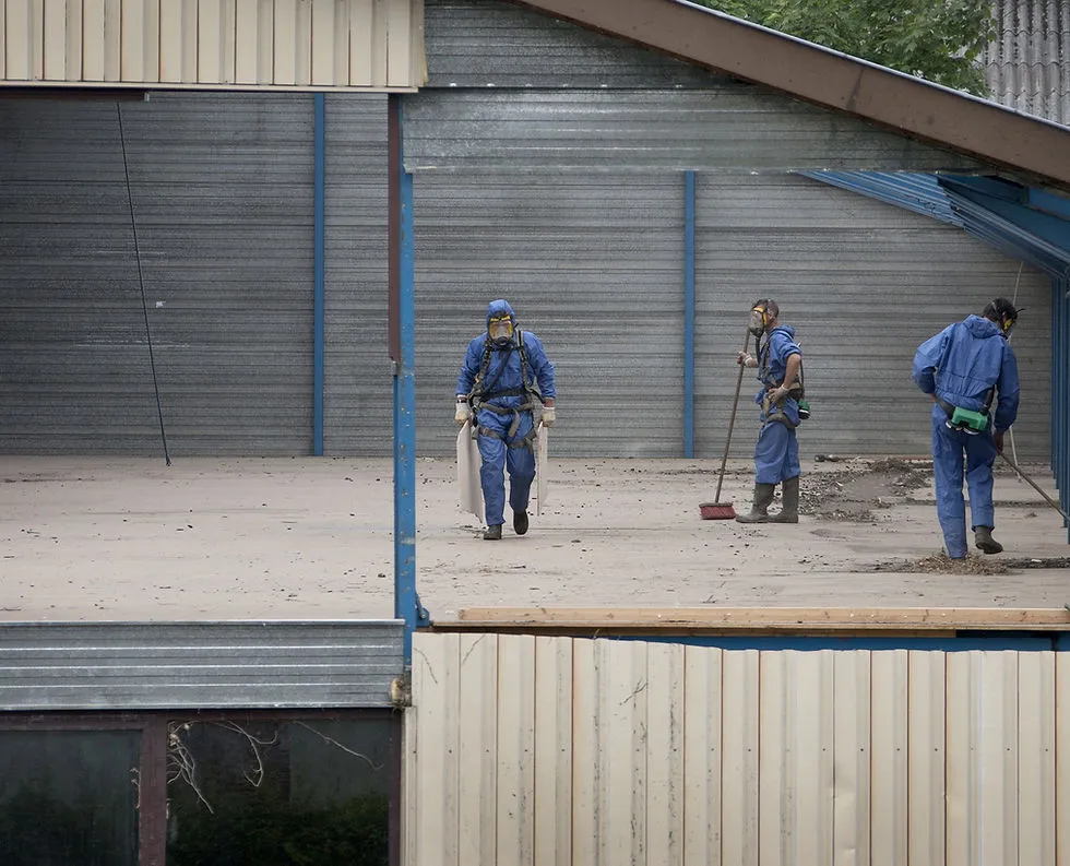 Workers in blue protective suits conducting cleanup operations inside a building for Curran Environmental Services Inc. in Petaluma.