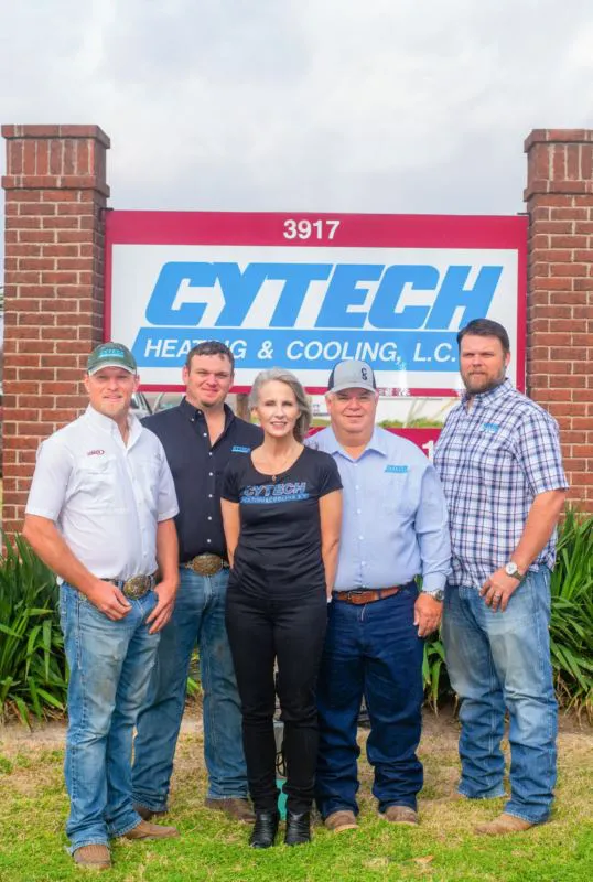 Five people standing in front of the Cytech Heating & Cooling sign in Edinburg.