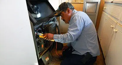 A technician from Cytech Heating & Cooling is conducting maintenance on HVAC equipment in Edinburg.